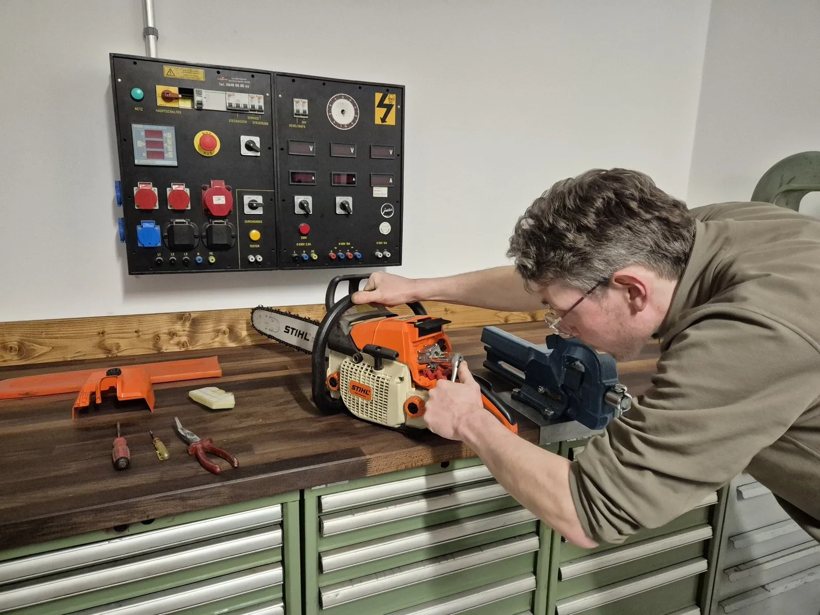 Sylvain Demiri réparant une tronçonneuse STIHL dans l'atelier MécaVal à Savièse